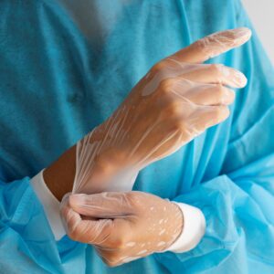 Docteur mettant des gants transparent blanc